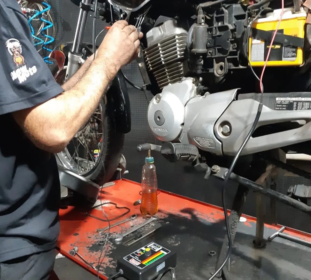 Motor aberto na bancada da oficina da New Moto Point